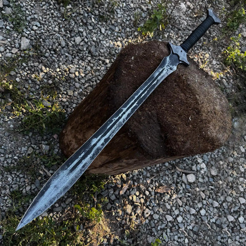Hand Forged Knight Sword In Spring Steel 35 Inch Full Tang resting on wooden log outdoors.