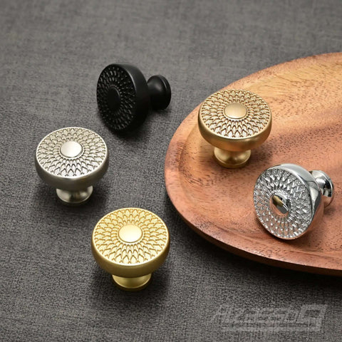 Polished Chrome Round Cabinet Knobs 10 Pack With Intricate Filigree Pattern And Decorative Cutouts For Cabinets And Drawers 1.4 Inch Diameter And Easy Grip displayed on a wooden tray with other colored knobs.