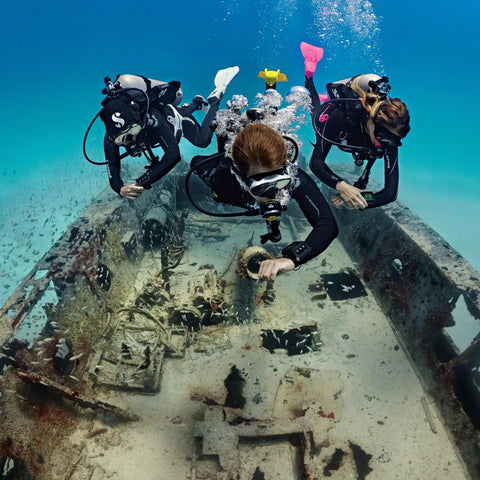 Divers using G2 Wrist Dive Computer And Transmitter Bundle With Hoseless Air Integration exploring underwater wreck.