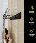 Side view of Guitar Wall Rack For Acoustic And Electric Guitars With Five Padded Arm Hangers And Adjustable Hangers Dual 24 Inch Slatwall Rails Black Wall Mount Organizer Made In USA mounted on a wall holding guitars.