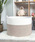 Extra Large 22x16 Inch Cotton Rope Storage Basket With Grab Handles A Rugged Yet Chic Woven Bin For Blankets Pillows Towels Laundry Toys Shoes And More Perfect For Easy Home Organization In Black Or Gray shown in a cozy room.