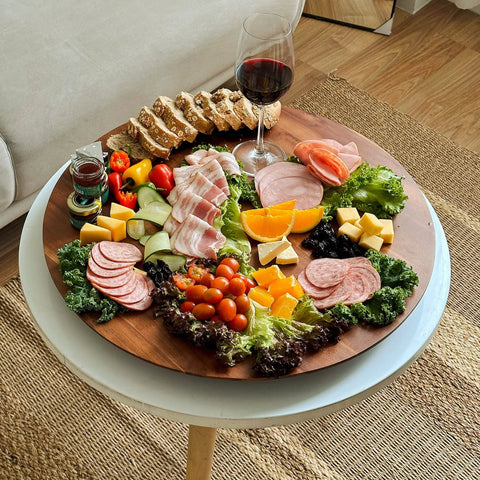 21 Inch Acacia Wood Lazy Susan For Tabletop Giant Round Turntable Serving Tray Next Level Charcuterie And Cheese Boards Platter Extra Large Organizer For Countertop Kitchen Revolution with assorted meats, cheese, and vegetables.