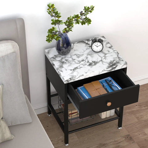 Black and white marble top nightstand with open drawer, decorative items, and a vase on a wooden floor