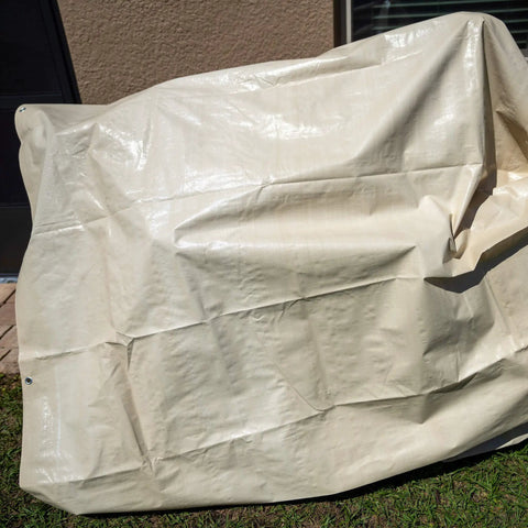Heavy Duty Waterproof Tarp 20 Ft By 30 Ft 12 Mil Thick Tan Tarp With Reinforced Corners and Rope Hem laying outside