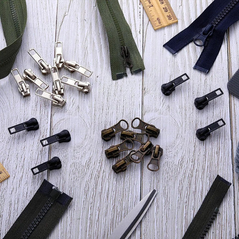 Size 5 Zipper Repair Kit with 12 sliders, 12 bottom stops, 24 top stops for metal, plastic, and nylon coil zippers on wooden background.