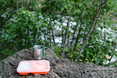 Ultra Handy Flexible Collapsible Mess Kit For Outdoor Survival Camping And Hiking BPA Free Kitchen Gear on rock in forest setting