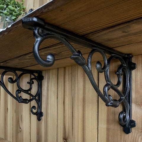 4 Pack Badass Cast Iron Shelf Brackets 11 By 7.5 Inch Antique Black Corbels With Screws And Anchors showing intricate vine pattern under wooden shelf.