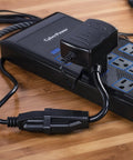 Six Inch Heavy Duty Extension Cord With Two Grounded Nema 5 15R Outlets and power strip on wooden surface