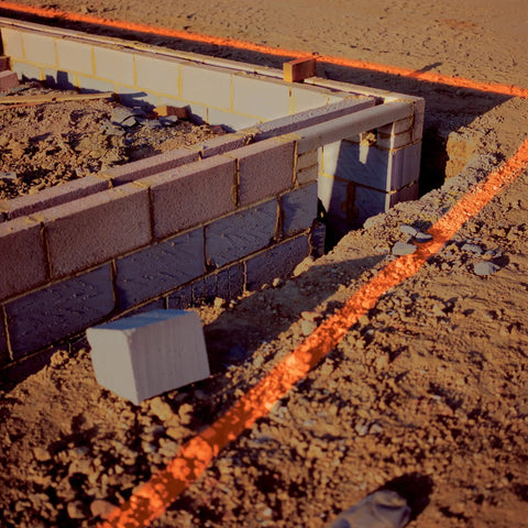 Construction site foundation marked with Industrial Choice M1400 Water Based Construction Marking Spray Paint 17 oz Gloss White.