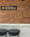 Notre Dame Fighting Irish 16 Inch Plastic Street Sign Wall Decor on brick wall, perfect for college football fan gear.