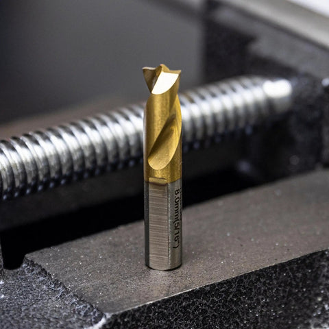 Close-up of Shop-Ready Spot Weld Drill Bit Set 8mm And Five Sixteenth Inch Pro Grade High Speed Cobalt Steel With Titanium Coating in vise.
