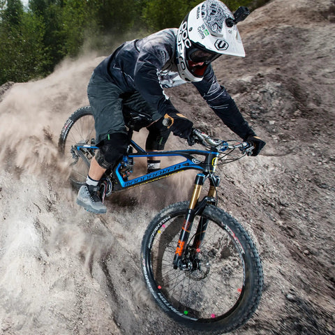 Mountain biker riding downhill with Combat II Mountain Bike Grips With Lock On Clamp Double Lock Security for solid hold.