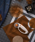 45mm Rotary Fabric Cutter with Ergonomic Loop Grip on craft table with fabric and beads