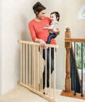 Walk-Through Top Of Stairs Baby Gate In Natural Wood With Four Point Mount, One Hand Release, Dual-Direction Swing, Installed At Stairs