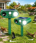 Two Pack Solar Ultrasonic Animal Repeller Set To Keep Cats, Deer And Other Pests And Critters Off Your Lawn And Garden, Easy Stake In Outdoor Deterrents That Recharge In Sun And Work Day And Night. Two green stake-mounted solar repellers in a garden