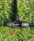 Close-up of three-way coupler from Six Pack Five Sixteenth Inch Drip Irrigation Tee Connectors Barbed Lock Fittings on grass