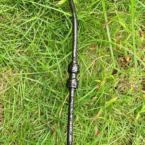 Black 1/4-inch drip irrigation straight quick-connect coupling on tubing installed in grass