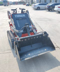 Front view of Mini Skid Steer Loader 1800 Lb Capacity With Four In One Bucket Attachment on pavement