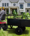 Heavy Duty Dump Cart For ATVs And UTVs, 1,600 Lbs Capacity, attached to lawn tractor on grass with house background