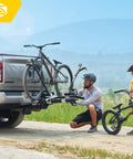 Man installs Modular Two In One Hitch Rack For Two Bikes Up To Eighty Pounds Tilts And Folds For Easy Storage on SUV
