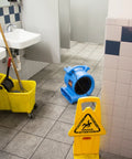 Blue One Half Horsepower Heavy Duty Air Mover drying bathroom floor with mop and caution sign