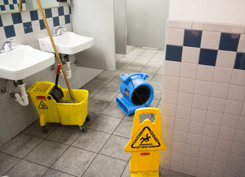Blue One Half Horsepower Heavy Duty Air Mover drying bathroom floor with mop and caution sign