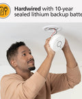 Top Shelf Smart Smoke Detector Delivering Wifi Connectivity Alexa Integration Hardwired Design With Battery Backup Voice And App Alerts Rock Solid Home Defense No Sweat Install Two Pack being installed by a person on the ceiling.