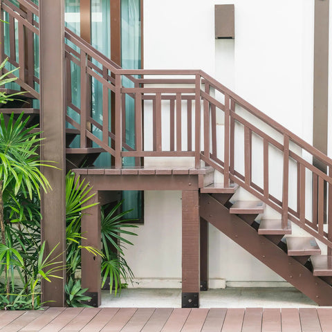 Wooden deck stairs with steel black Fence Post Holder Ground Spike for Concrete Deck, 4x4 Post Base Anchor visible at base.