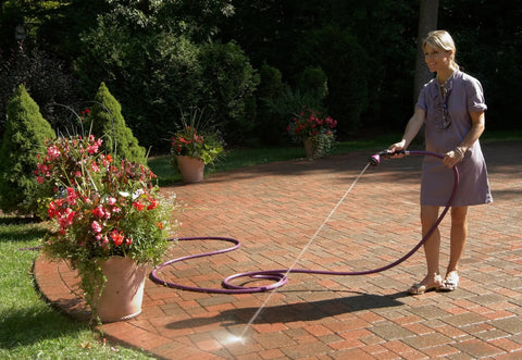 Woman using One Touch Shower And Stream Garden Watering Wand With Dual Flow Modes Shower And Stream Green on patio plants