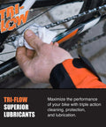 Person applying lubricant to bicycle chain with Tri-Flow Superior Lubricants.