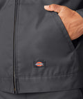 Close-up of Classic Mens Lined Eisenhower Jacket Heavy Duty Workwear Rugged Poly Cotton Twill Wrinkle Resistant Charcoal Plus Size 3X pocket and logo.