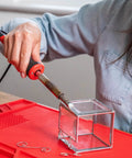 Person using Power Grip Variable Wattage Soldering Station 20 To 80W with Built-In Safety Rest on glass cube DIY project