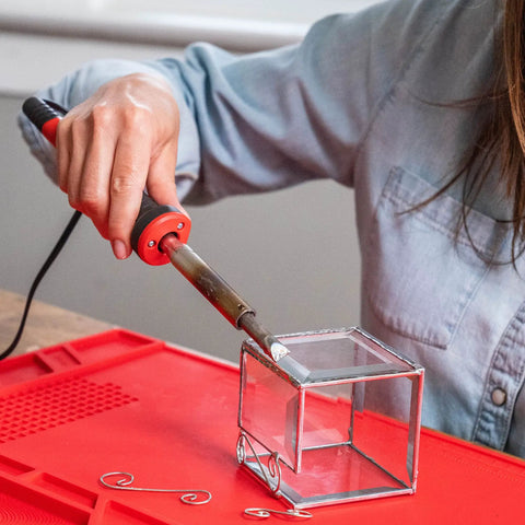 Person using Power Grip Variable Wattage Soldering Station 20 To 80W with Built-In Safety Rest on glass cube DIY project