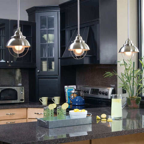 Modern kitchen with stainless steel pendant lighting over granite countertops.
