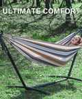 Person relaxing in a double hammock with stand for outdoor and indoor use portable space saving heavy duty steel frame easy assembly 2 person capacity 450 lbs kick back coffee