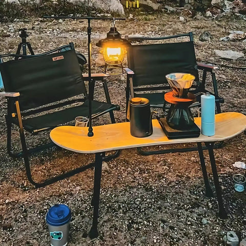 Portable folding table legs crafted from skateboards supporting coffee setup in outdoor camping scene.