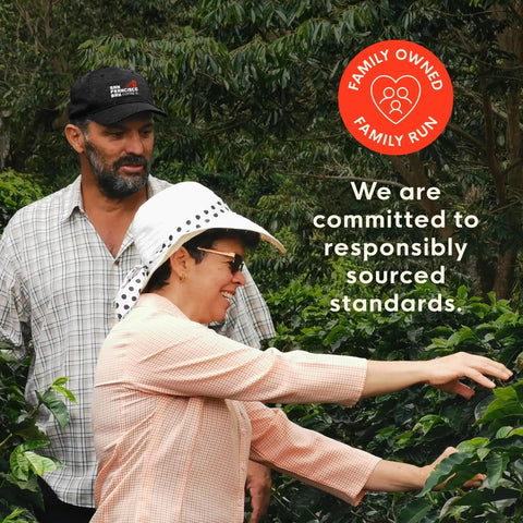 People inspecting coffee plants with text 'Family Owned Family Run' and 'We are committed to responsibly sourced standards'