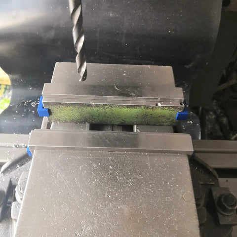 Close-up of Magnetic Parallel Keepers For Vise And CNC Machining with aluminum build and blue powder coat, attracting ferrous chips.