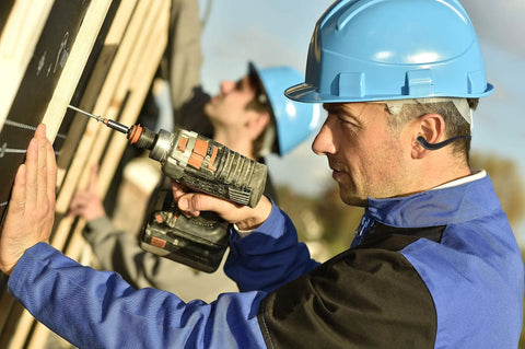 Construction worker wearing blue helmet and using drill, fits Two Pairs Soft Banded Silicone Reusable Ear Plugs For Sleep And Swim With 22dB NRR