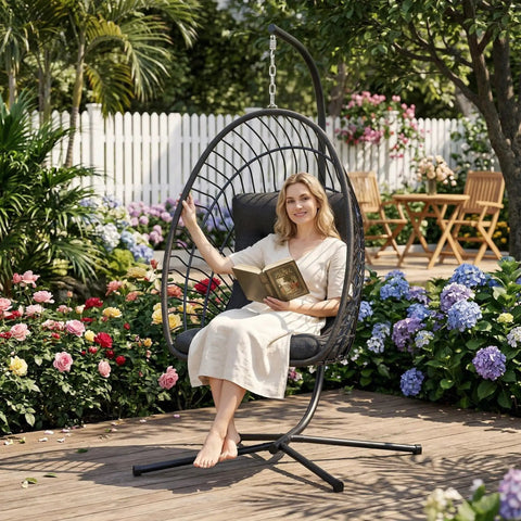 Person relaxing on an Egg Chair With Stand For Indoor Outdoor Use, Foldable Rattan Wicker Hanging Swing For Chill Lounging in a garden