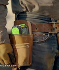 Worker carrying a self leveling green cross line laser level with 100 ft range for DIY construction in a tool belt, 3x2.6x2.6 inches.