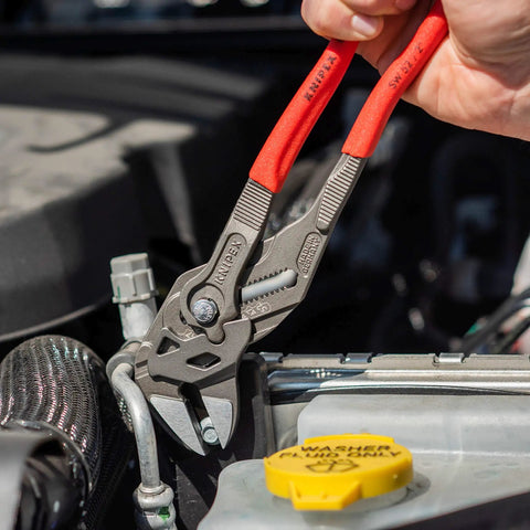 Heavy Duty 10 Inch Pliers Wrench With Adjustable Smooth Jaws being used on a car's engine, showcasing grip on a metallic fitting.