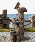 Chill Four Tier Pelican And Driftwood Outdoor Cascading Water Fountain on porch with ocean view, resin and weatherproof design