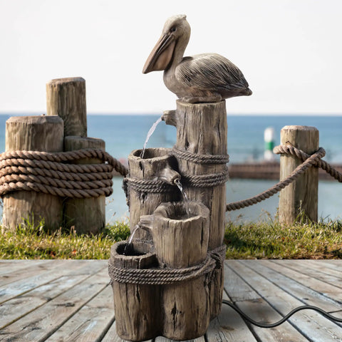 Chill Four Tier Pelican And Driftwood Outdoor Cascading Water Fountain on porch with ocean view, resin and weatherproof design