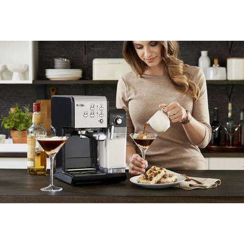 Woman using Super Sleek Programmable Espresso And Cappuccino Maker Featuring Automatic Milk Frother And 19 Bar Pump on kitchen counter.