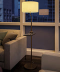 Brass Finish USB Floor Lamp With Built In Tray And USB Port beside a couch in a modern living room with window view.