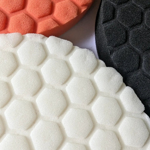 Badass 6-Inch Foam Buffing Pads for Cars in white, orange, and black, showcasing hexagonal texture for effective polishing.