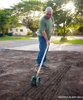 Man using Precision Garden Seeder For Metal Vegetable Planting Durable Handheld Planter For Easy Sowing Of Greens Beets Carrots.