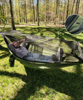 Man relaxing in Bug Free Camping Hammock With Mosquito Net in forest, demonstrating easy setup and breathable mesh.