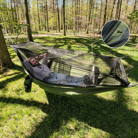 Man relaxing in Bug Free Camping Hammock With Mosquito Net in forest, demonstrating easy setup and breathable mesh.